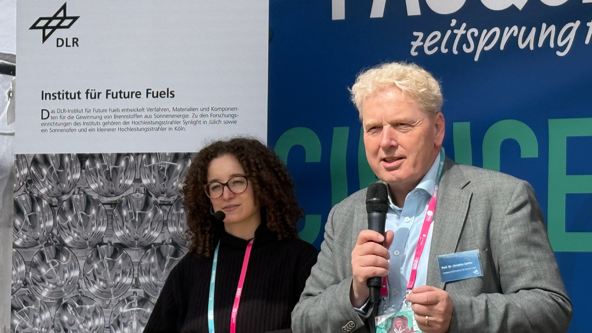 Christian Sattler welcomed the audience with an overview of DLR's research activities at the Jülich site. Jana Barabas (in the background) then began her presentation.