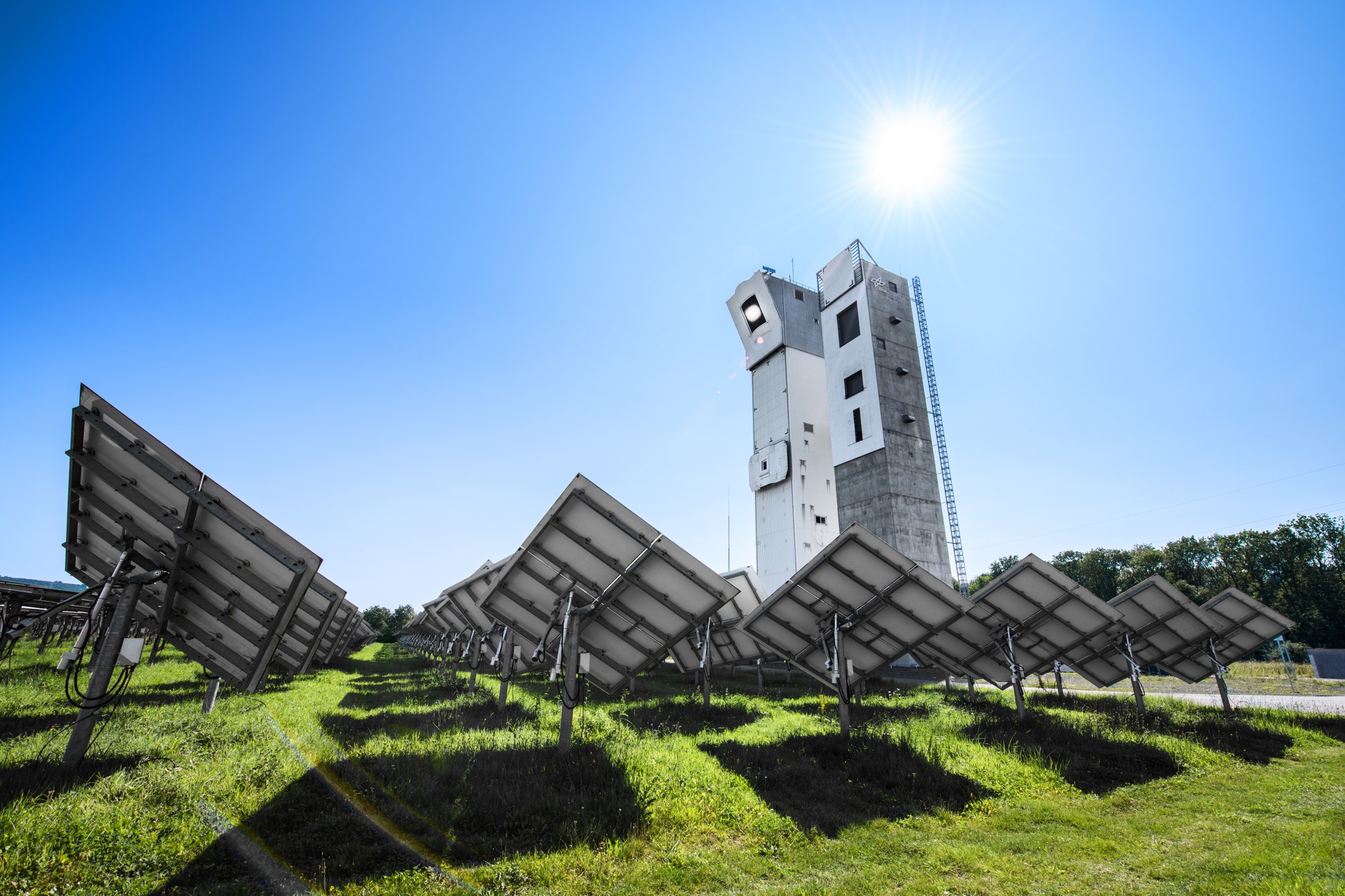A picture of the solar towers in Jülich with mirrors on a meadow