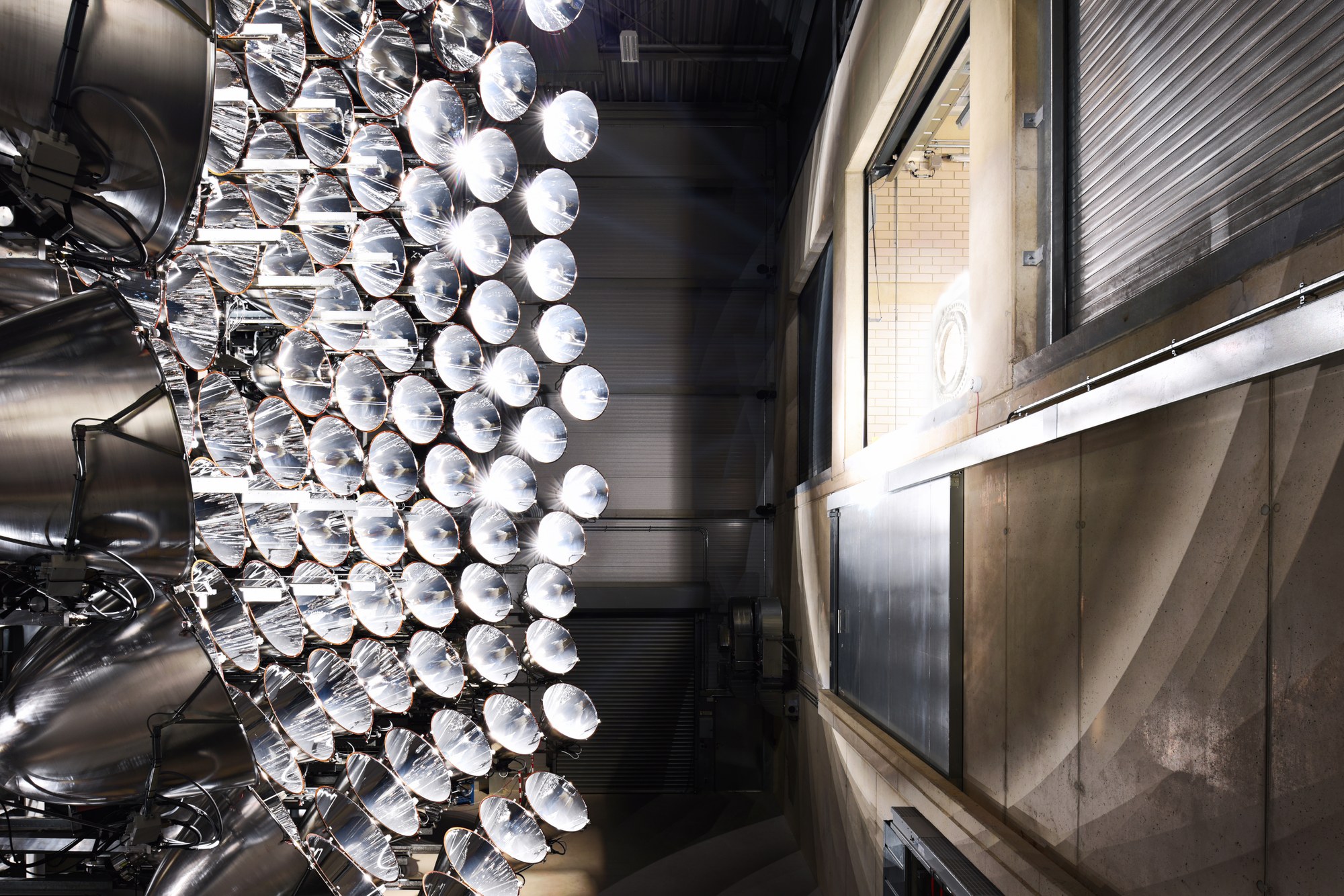The High-flux solar simulator Synlight at DLR's Jülich site irradiates one of the three experimental chambers.
