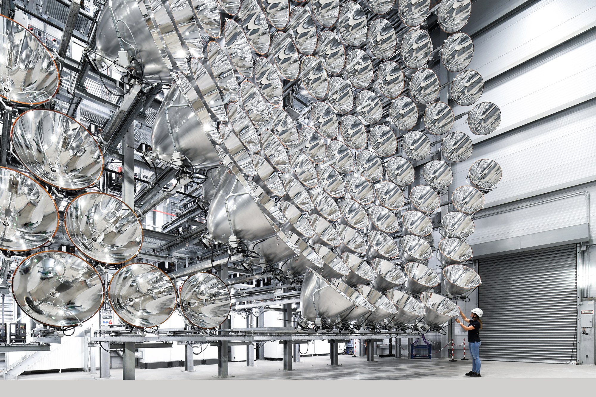 A researcher stands in front of the wall of 149 high-power radiators in Synlight.