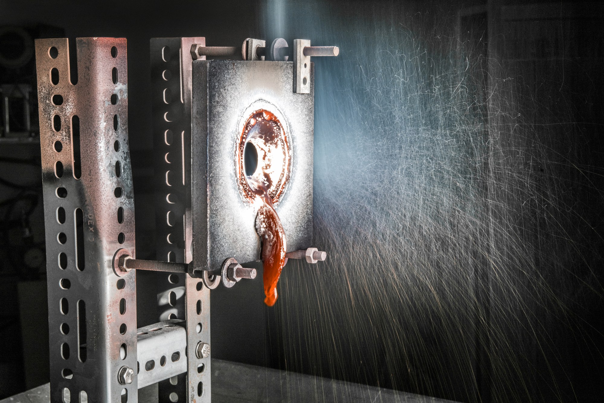 A steel plate in which a hole was burned with the help of concentrated solar radiation.