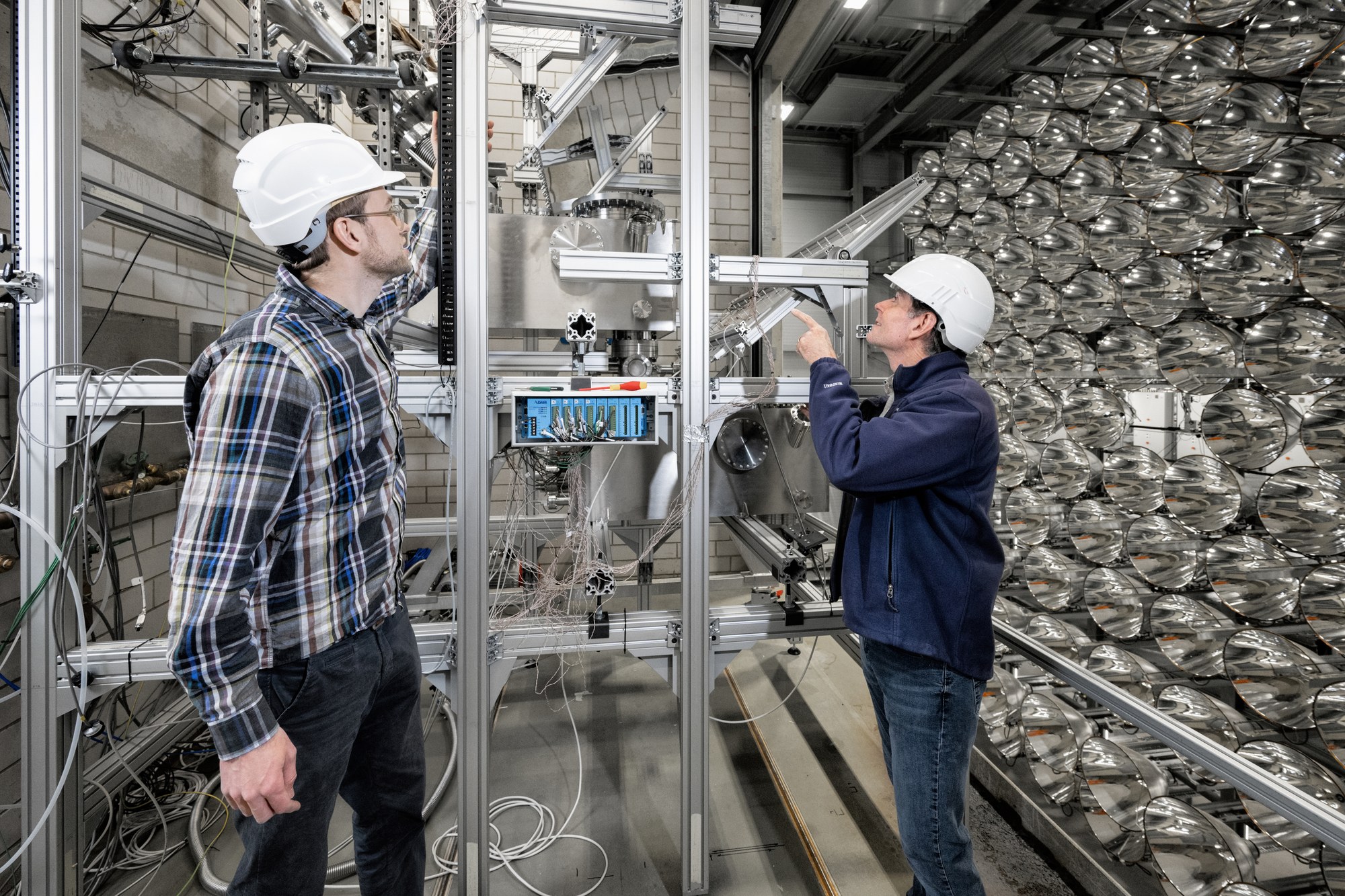 A researcher from DLR (left) and Anthony McDaniel from Sandia National Laboratories (right) at the facility
