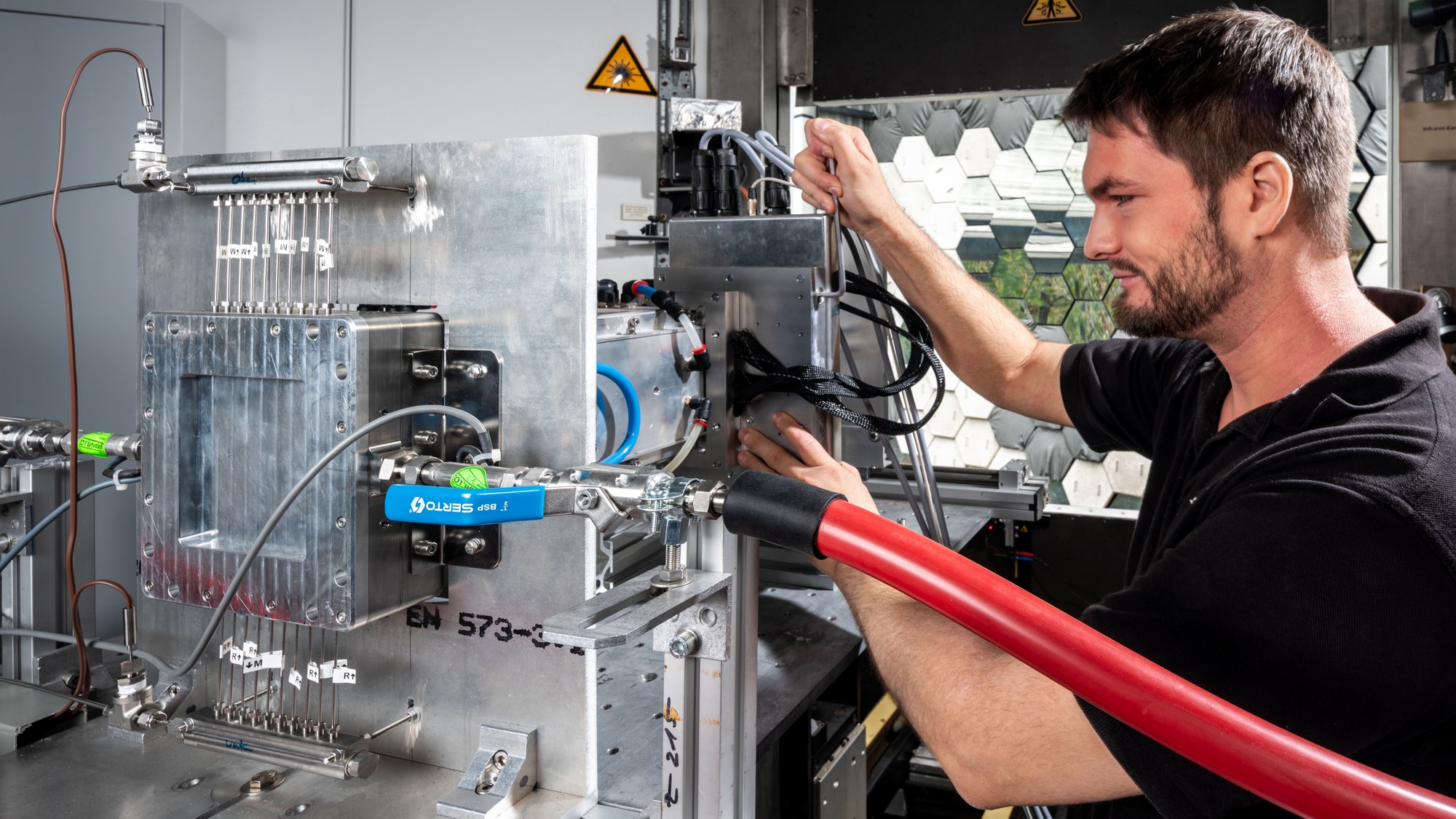 A DLR researcher checks the components of the reactor before the tests in the Cologne solar furnace.