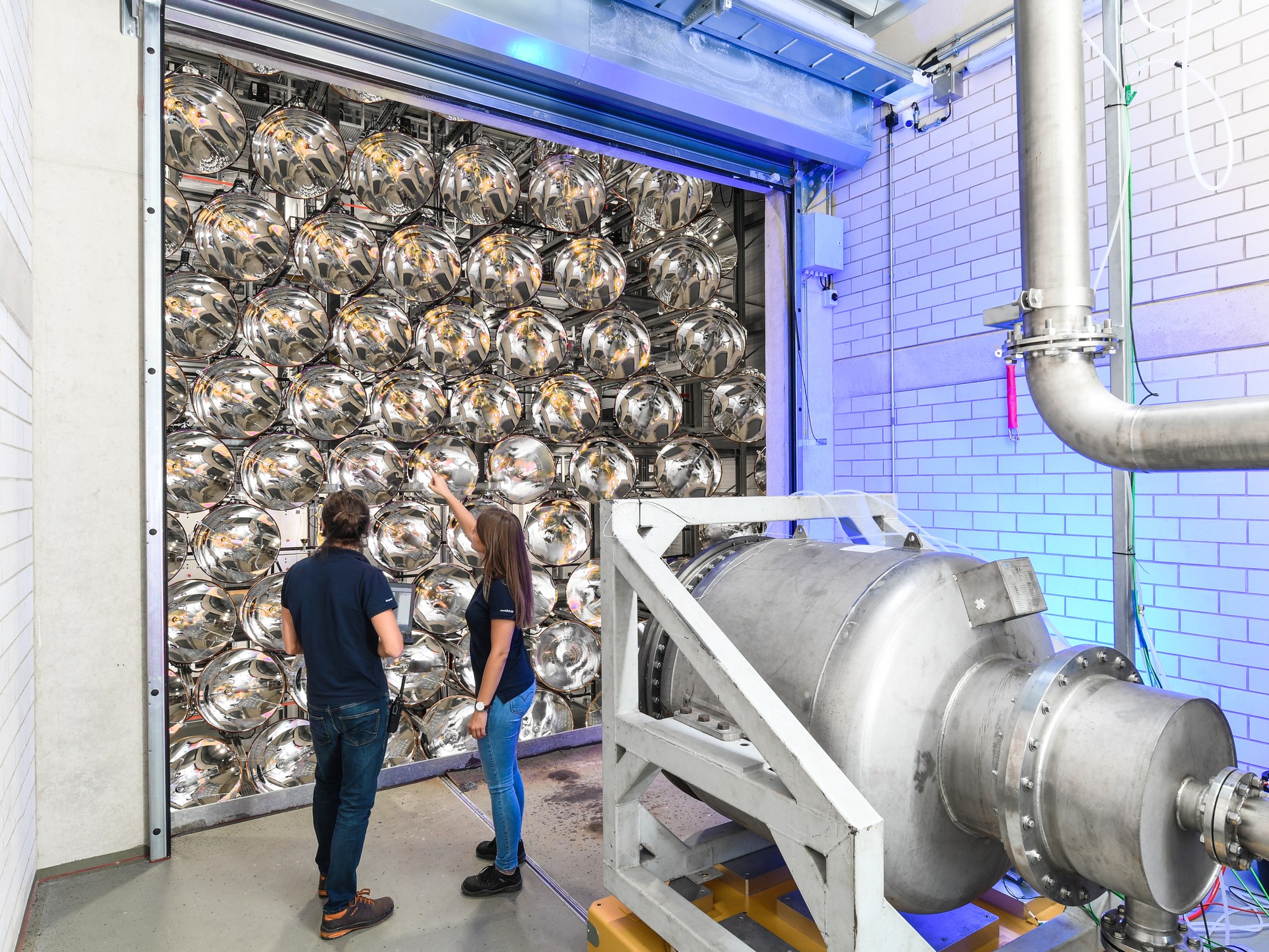 Two researchers stand in one of the three test chambers of Synlight.