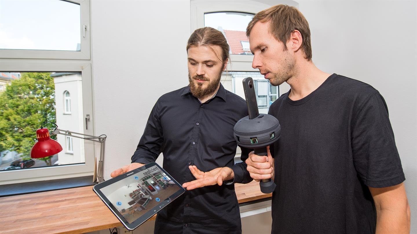 Silvan Siegrist and Arne Tiddens look at a tablet.