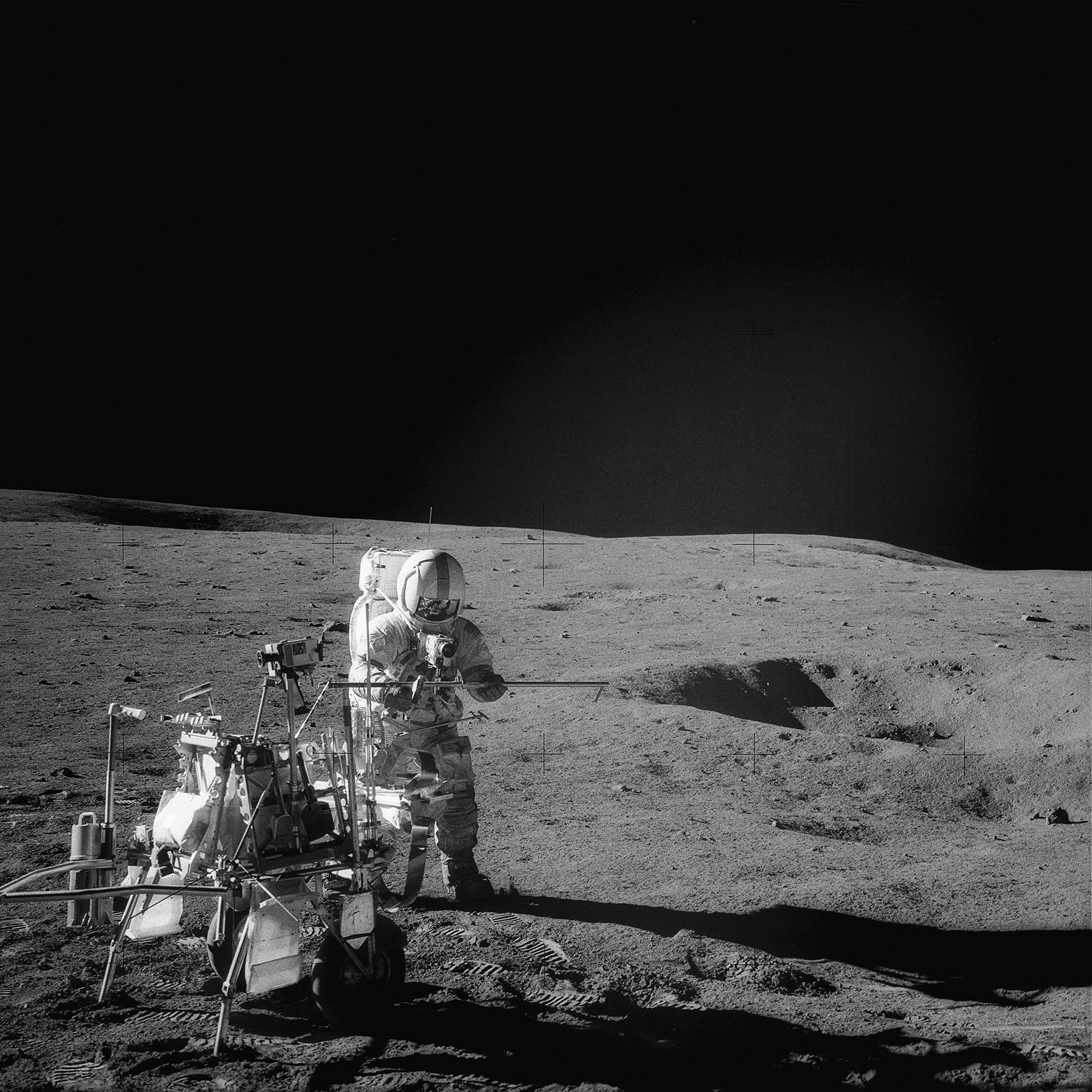Alan Shepard removes a tool from the equipment transporter on the lunar surface
