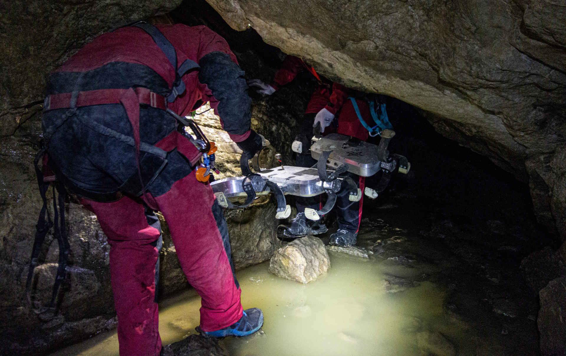 Researchers transport Scout into the cave