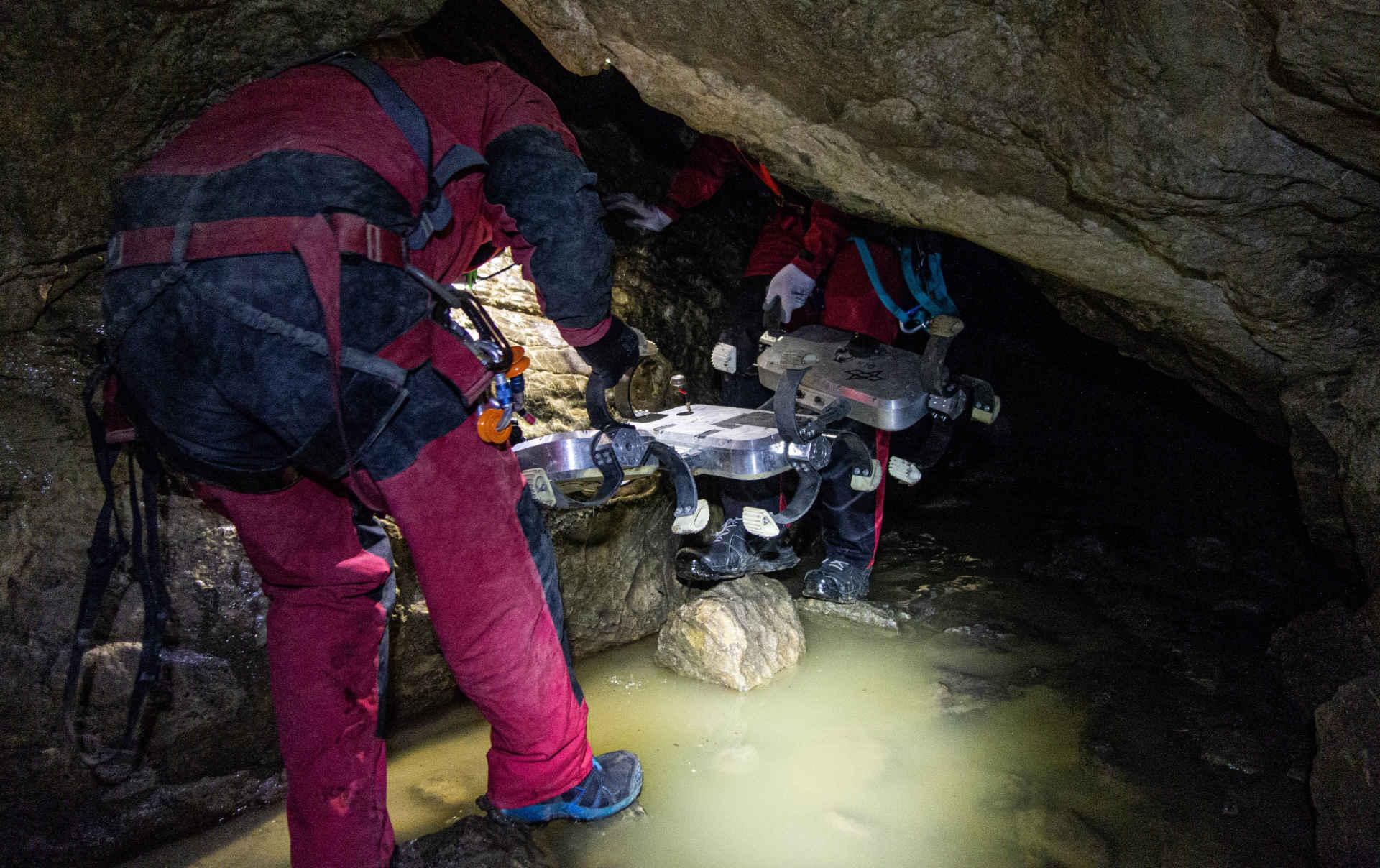 Researchers transport Scout into the cave