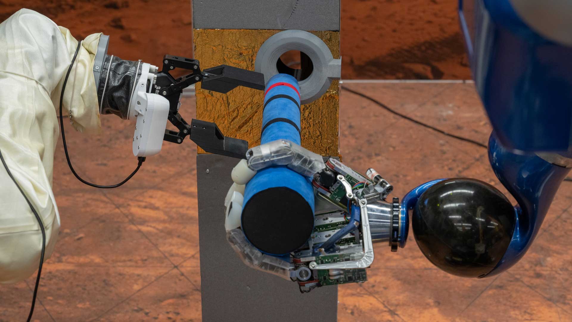 Two robotic hands cooperating to handle a tool