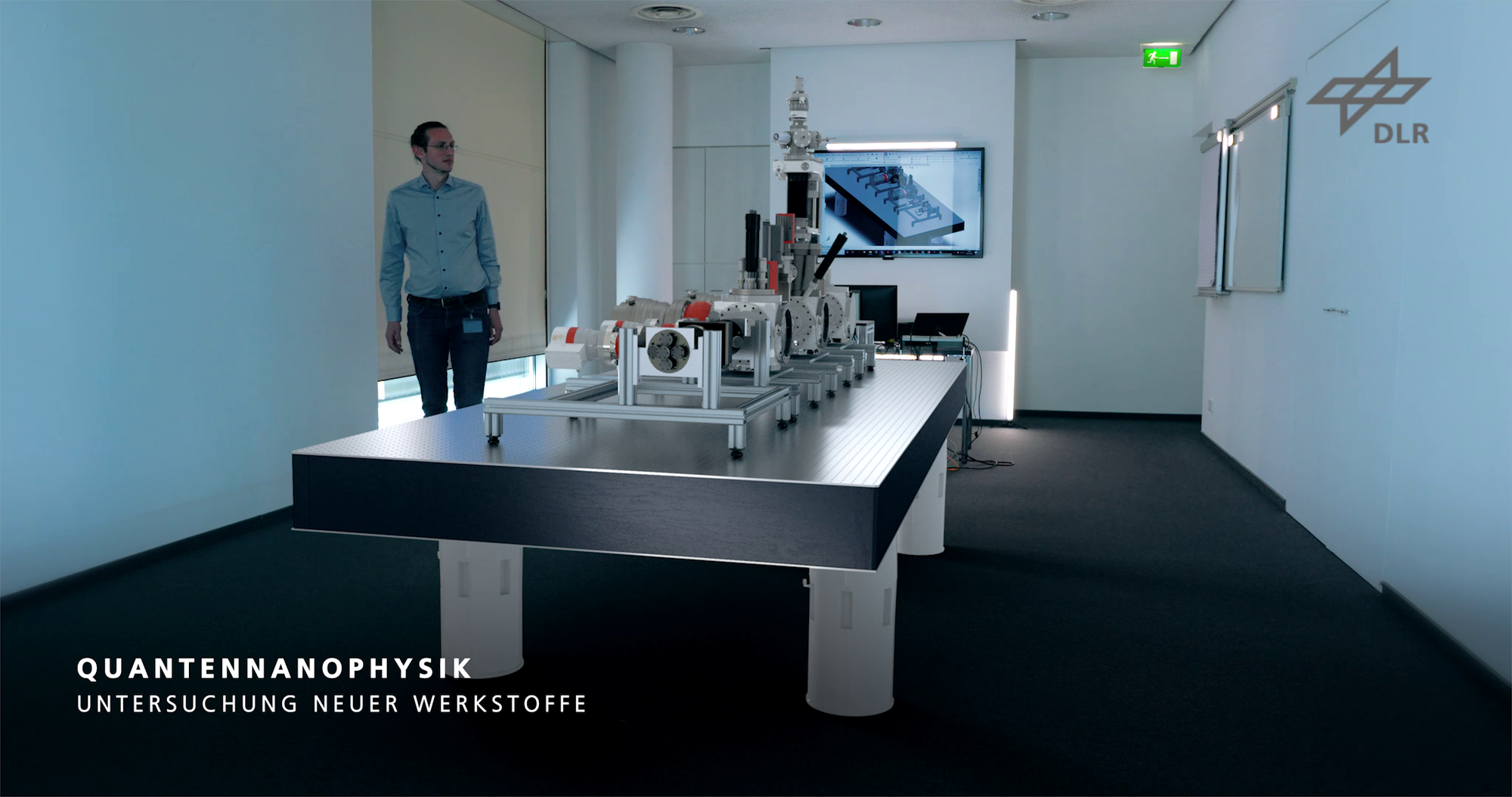 Scientist stands in front of an optical table