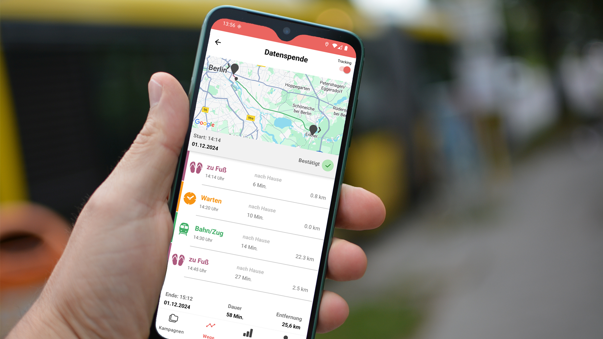 You can see someone holding a smartphone with the MovingLab app in one hand. A busy road can be seen in the background.