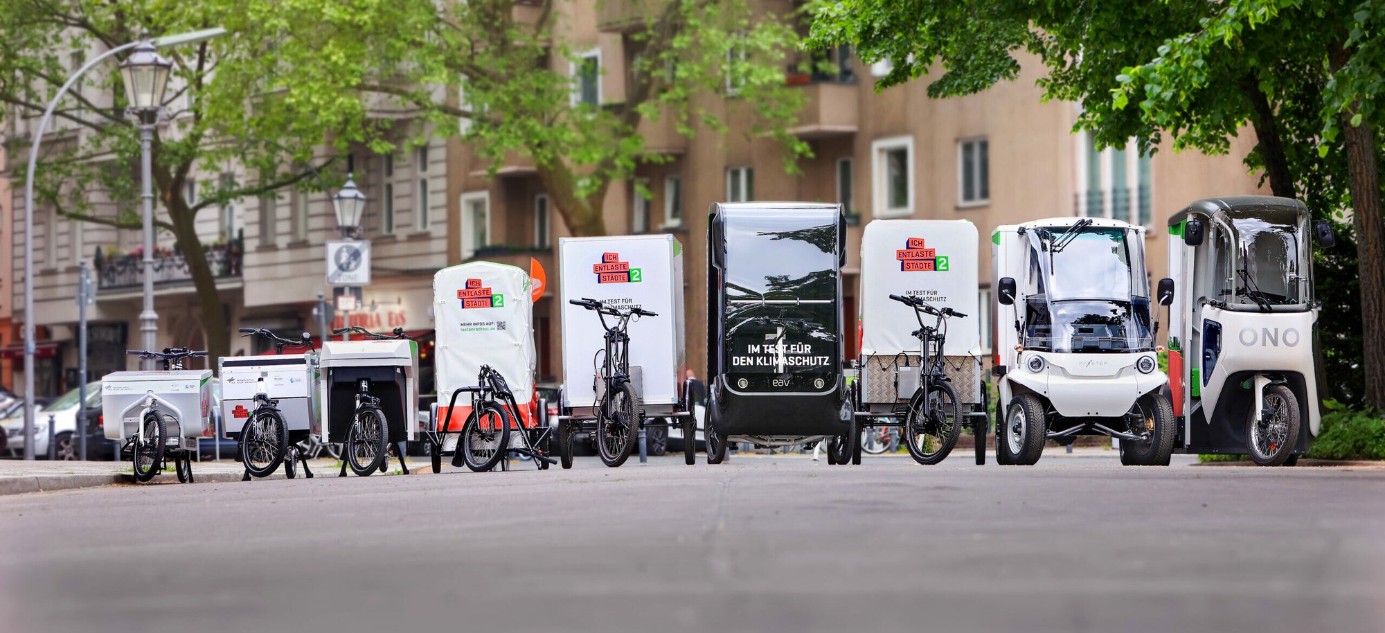 Various cargo bikes are lined up in a row.