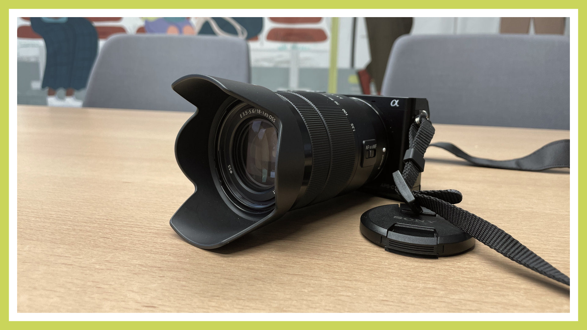 A DSLR camera is visible, standing on a table. The lens cap has been removed and is lying next to the camera.