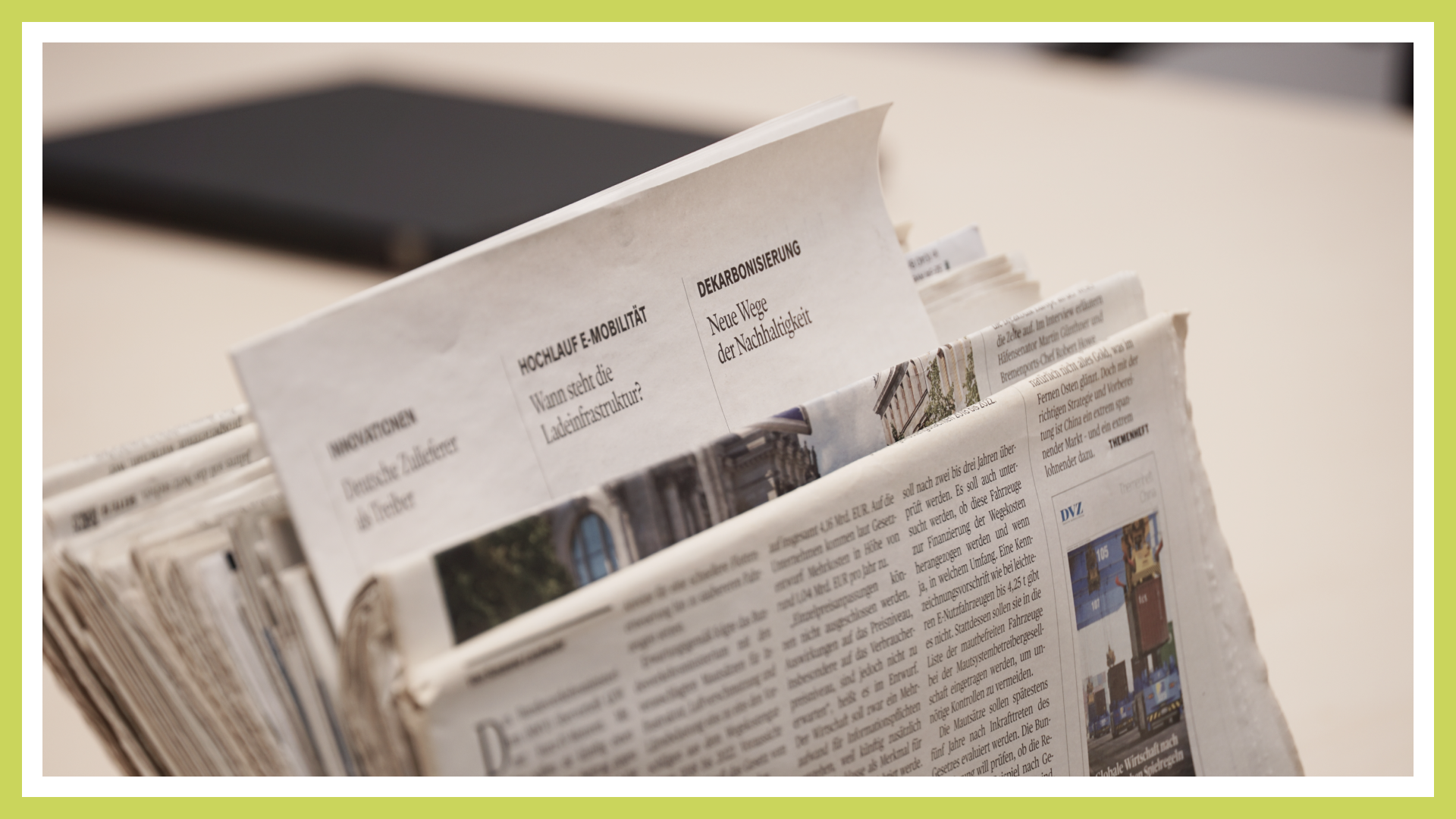 A stack of newspapers is visible, with the focus on the word "decarbonization."