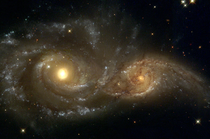 Zwei Galaxien ziehen sich gegenseitig an. Irgendwann werden sie sich zu einer großen Galaxie vereinigen. Die Anziehungskräfte, die diese Ansammlungen von vielen Milliarden Sternen aufeinander ausüben, müssten eigentlich dafür sorgen, dass die Ausdehnung des Weltalls allmählich verlangsamt wird. Stattdessen beschleunigt sie sich – von solchen Ausnahmen abgesehen – immer mehr. 
Bild: NASA, ESA, STScI