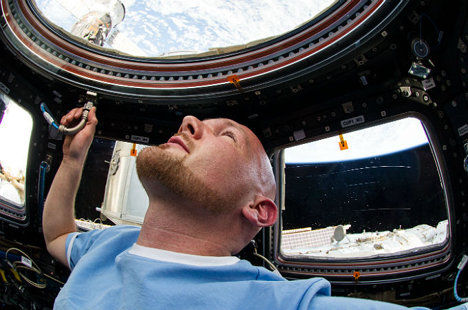 Alexander Gerst schaut aus der ISS auf die Erde, die hier „über“ ihm zu sein scheint. Aber er müsste sich nur „auf den Kopf“ stellen und schon wäre die Erde „unter“ ihm. Bild: NASA, ESA