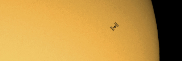 Die Internationale Raumstation ISS vor der Sonne. Natürlich haben sich die Astronauten auf ihrer Bahn um die Erde nicht in Richtung Sonne verflogen. Aber unser DLR-Kollege Rolf Hempel hat es geschafft, die Station genau in dem Moment fotografisch einzufangen, als sie – vom Boden aus gesehen – vor der Sonne vorbeigerast ist! Bild: Rolf Hempel  